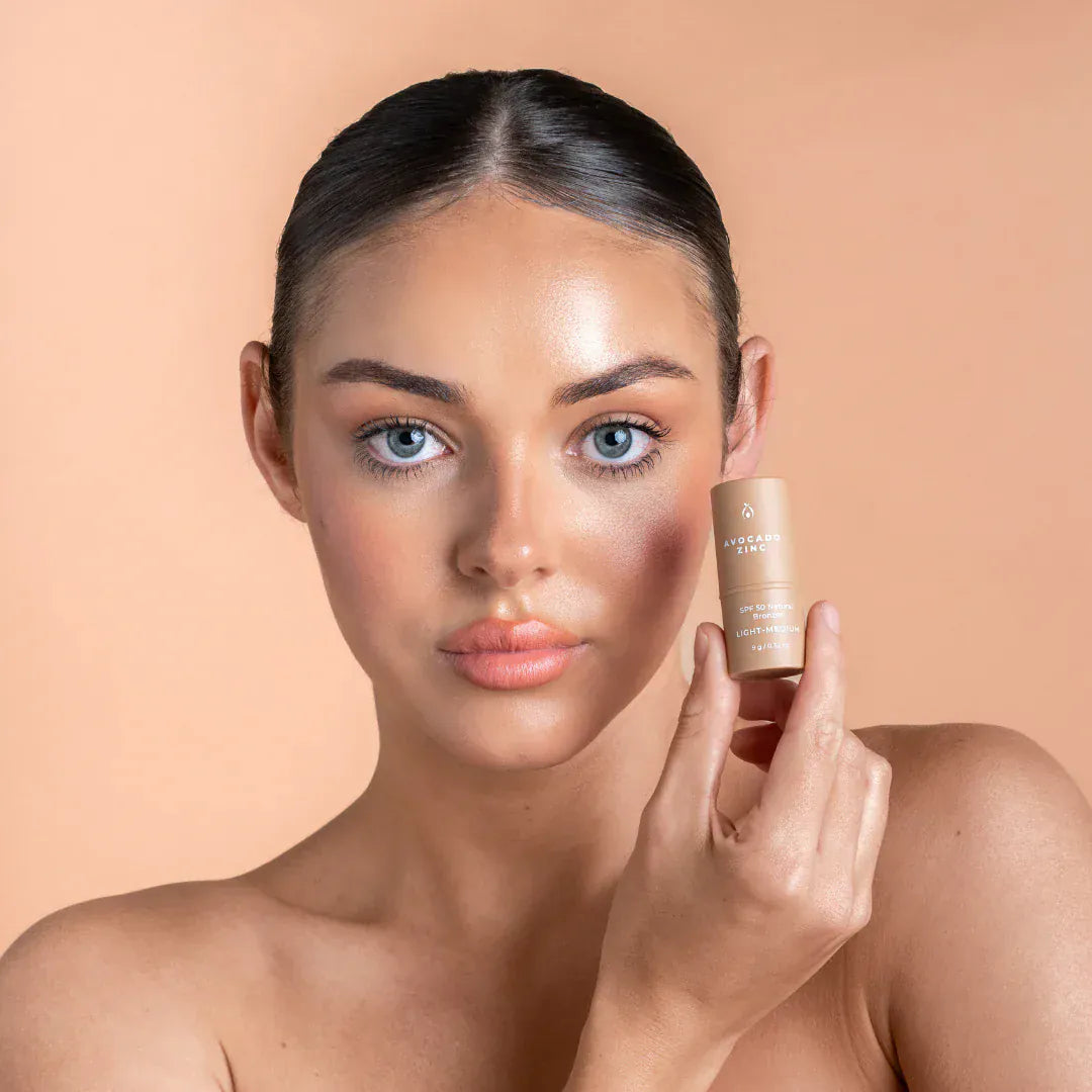 Model holding Avocado Zinc SPF 50 Natural Bronzer, showcasing its natural bronzed glow and mineral sun protection benefits.