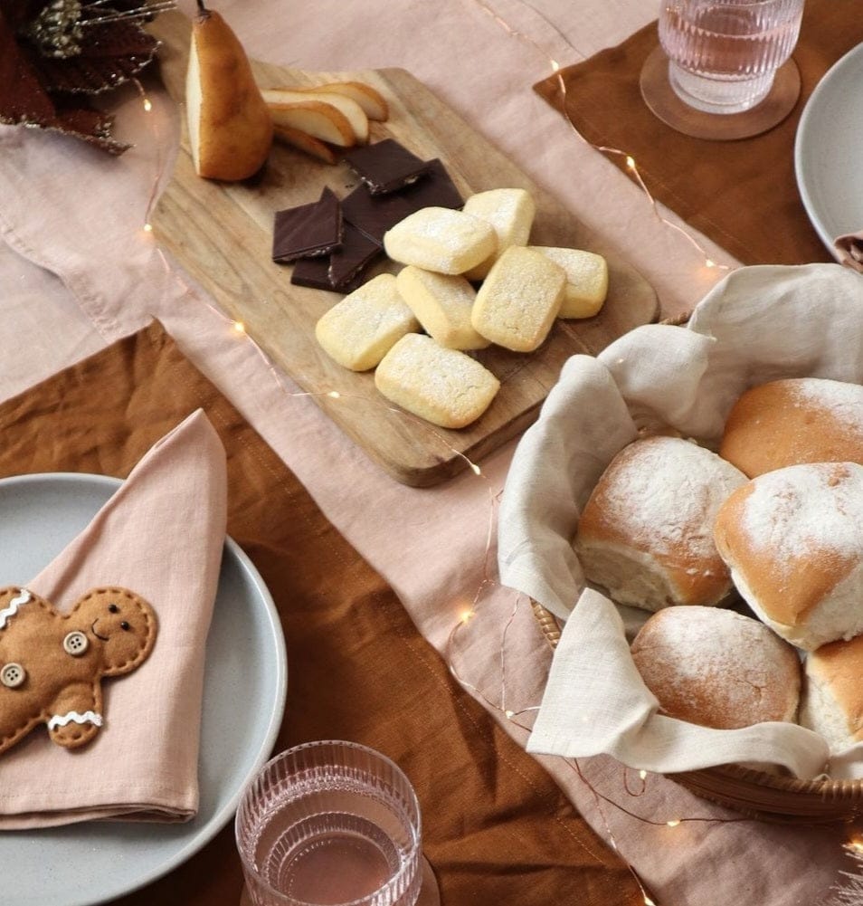 Linen Placemats Tobacco with assorted baked goods and a table setting featuring warm colors and textures.