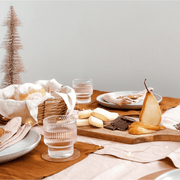 Linen Table Runners Blush set on a dining table with gourmet snacks and drinks, creating an elegant dining atmosphere.