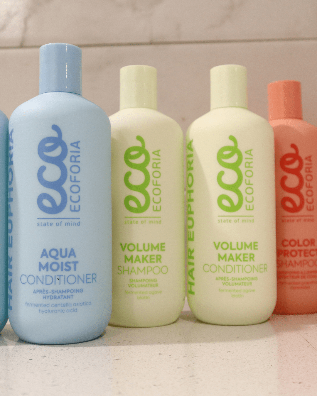 Bottles of Ecoforia Volume Maker Conditioner and Shampoo on a countertop, showcasing lightweight formula for enhancing hair volume and fullness.