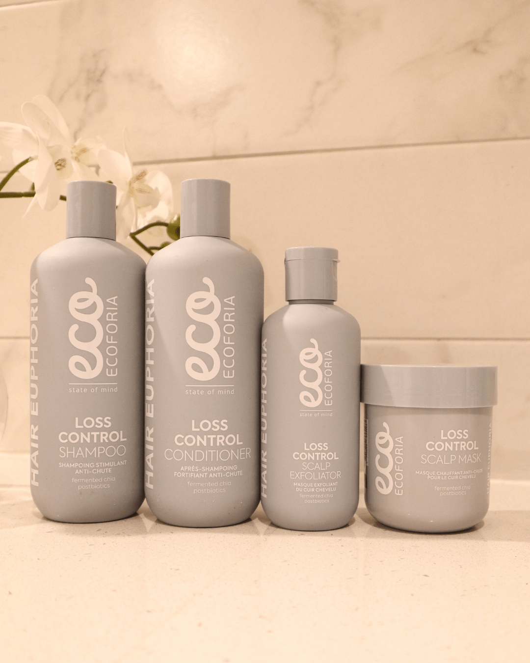 Ecoforia Loss Control Scalp Mask 200ml alongside shampoo, conditioner, and exfoliator in a bathroom setting.