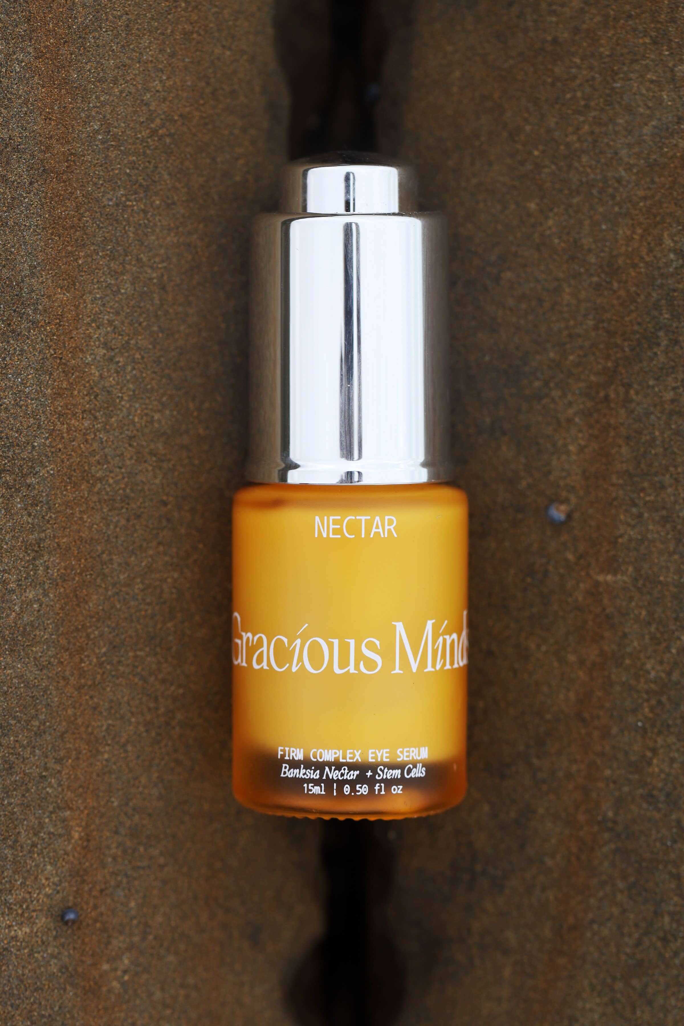 Gracious Minds Nectar Firming Eye Serum Elixir bottle on a textured background