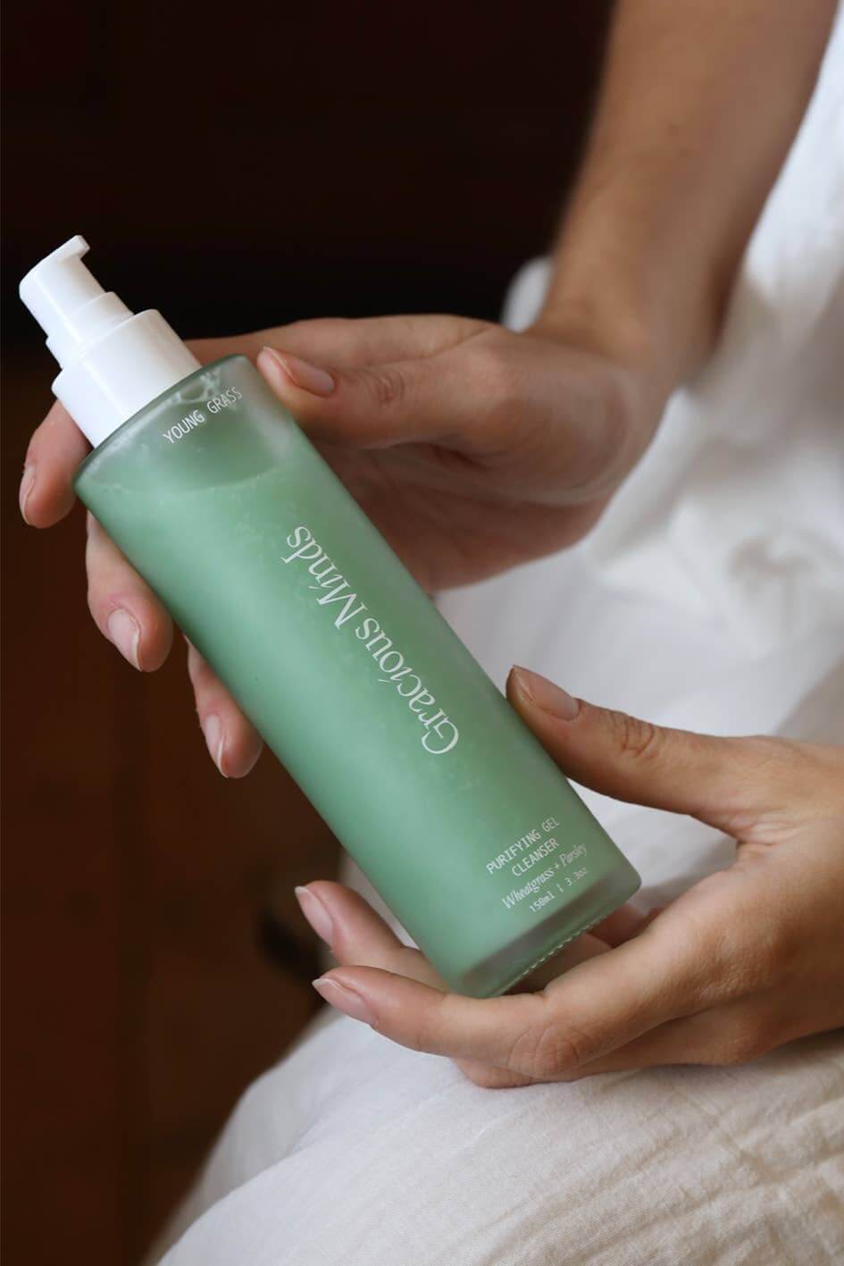 Gracious Minds Young Grass Purifying Gel Cleanser 150ml bottle held in hand, perfect for a refreshing daily face cleanse.
