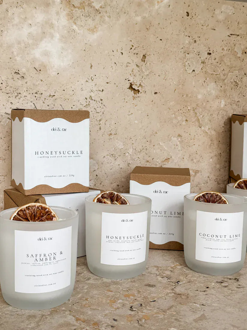 Coconut Lime Candle displayed among other candle products in elegant packaging on a natural stone surface.