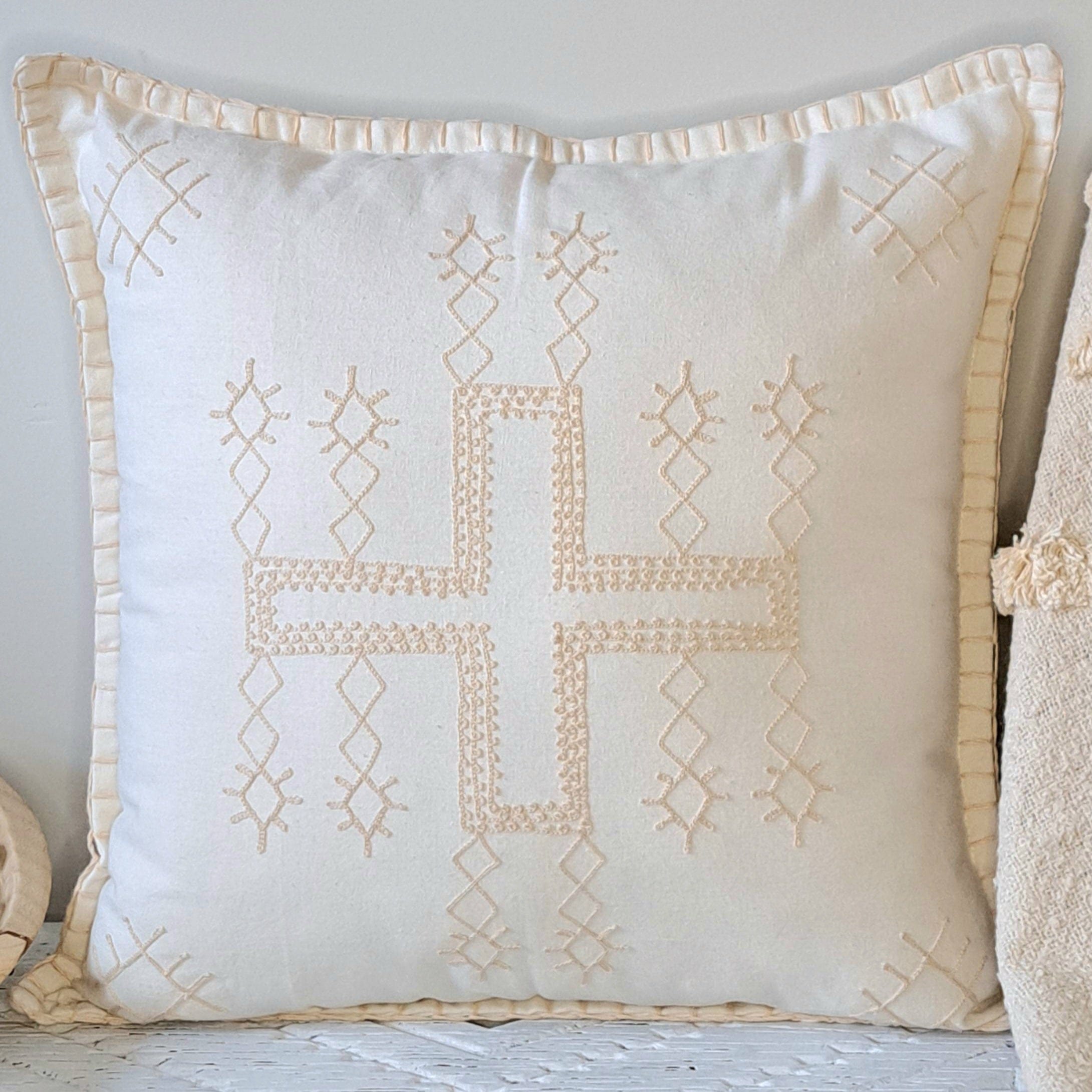 Boho Cross Cushion Natural showcasing a stitched cross pattern on a white cotton base with a textured neutral design.