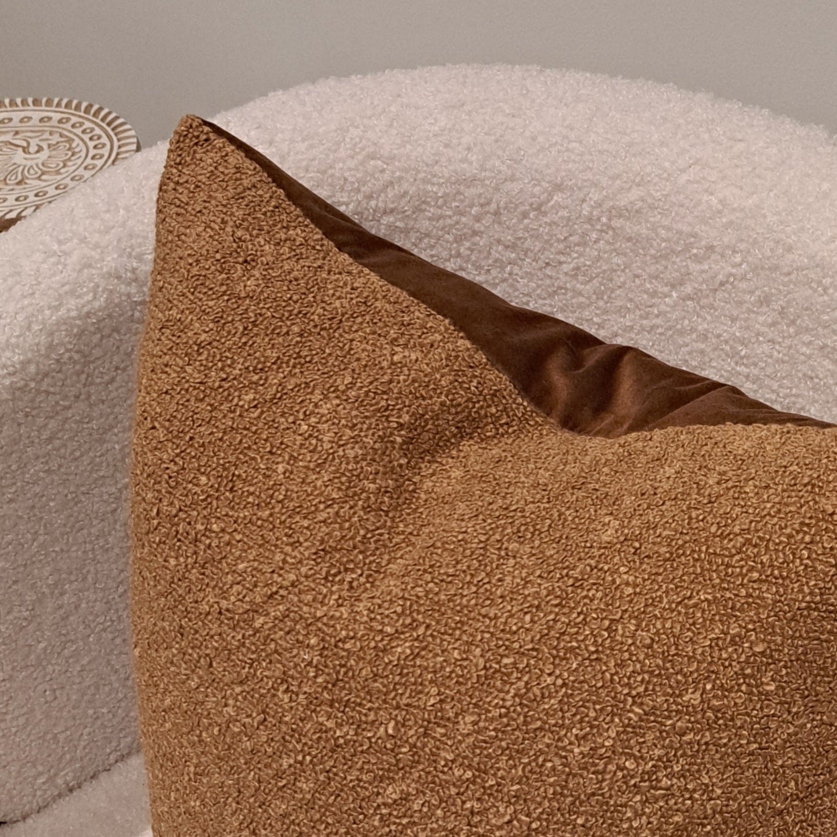 Boucle Cushion Cover Toffee on a cozy chair showcasing its soft texture and warm tone for home decor.