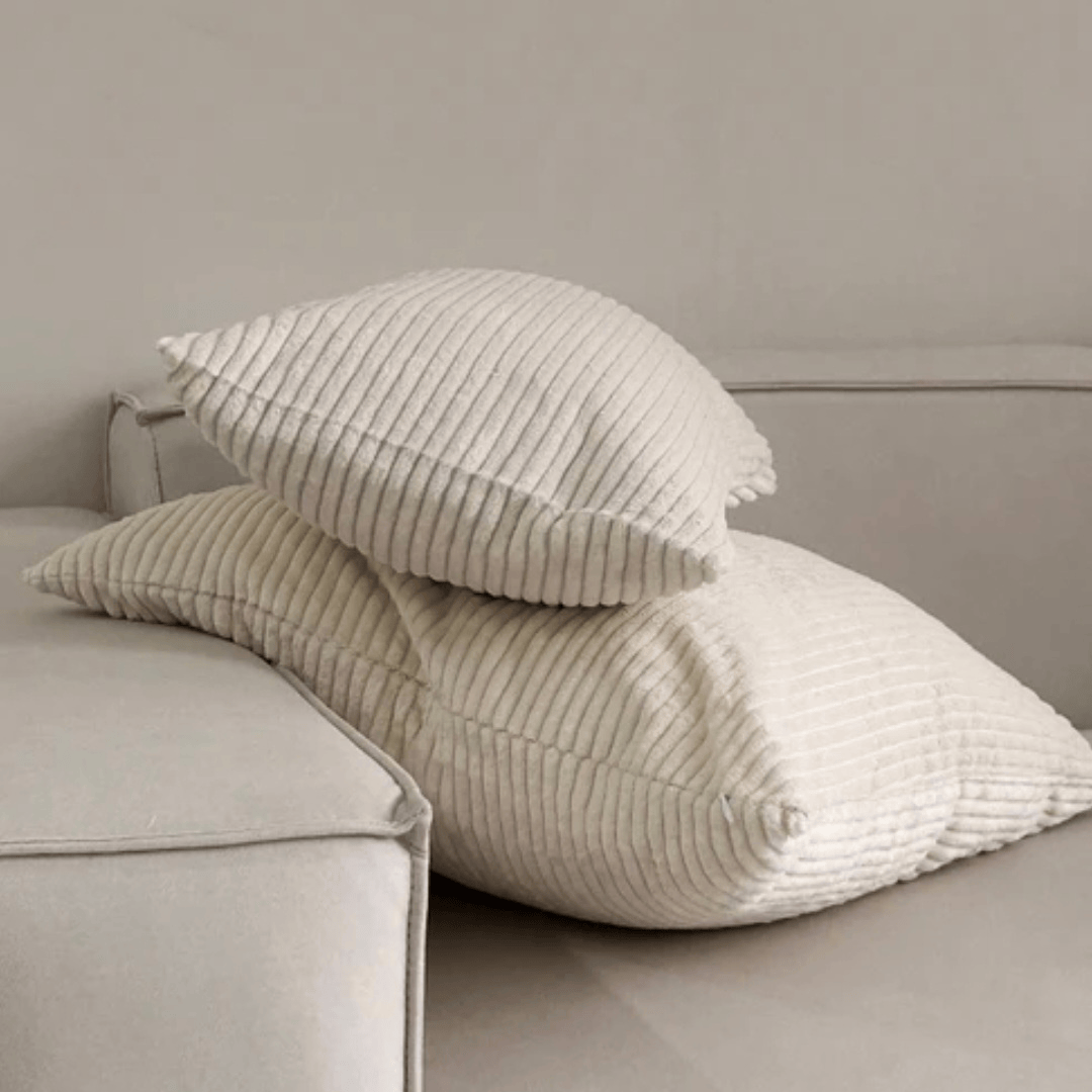 Corduroy Cushion Cover Almond displayed on a soft sofa, showcasing its velvety texture and calming design.