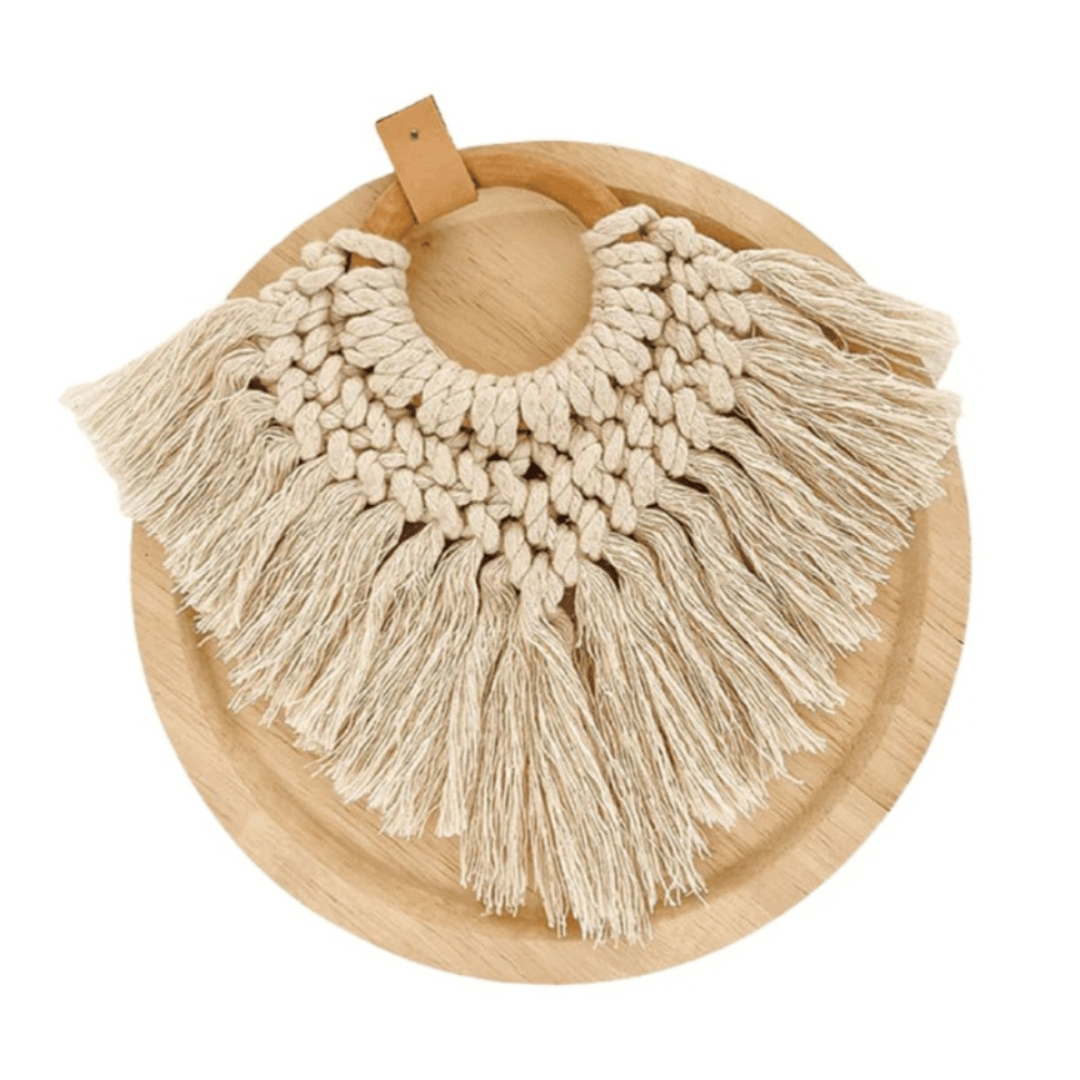 Nahla Macrame Cushion Accessory displayed on a wooden plate showcasing intricate macramé knots and tassels.