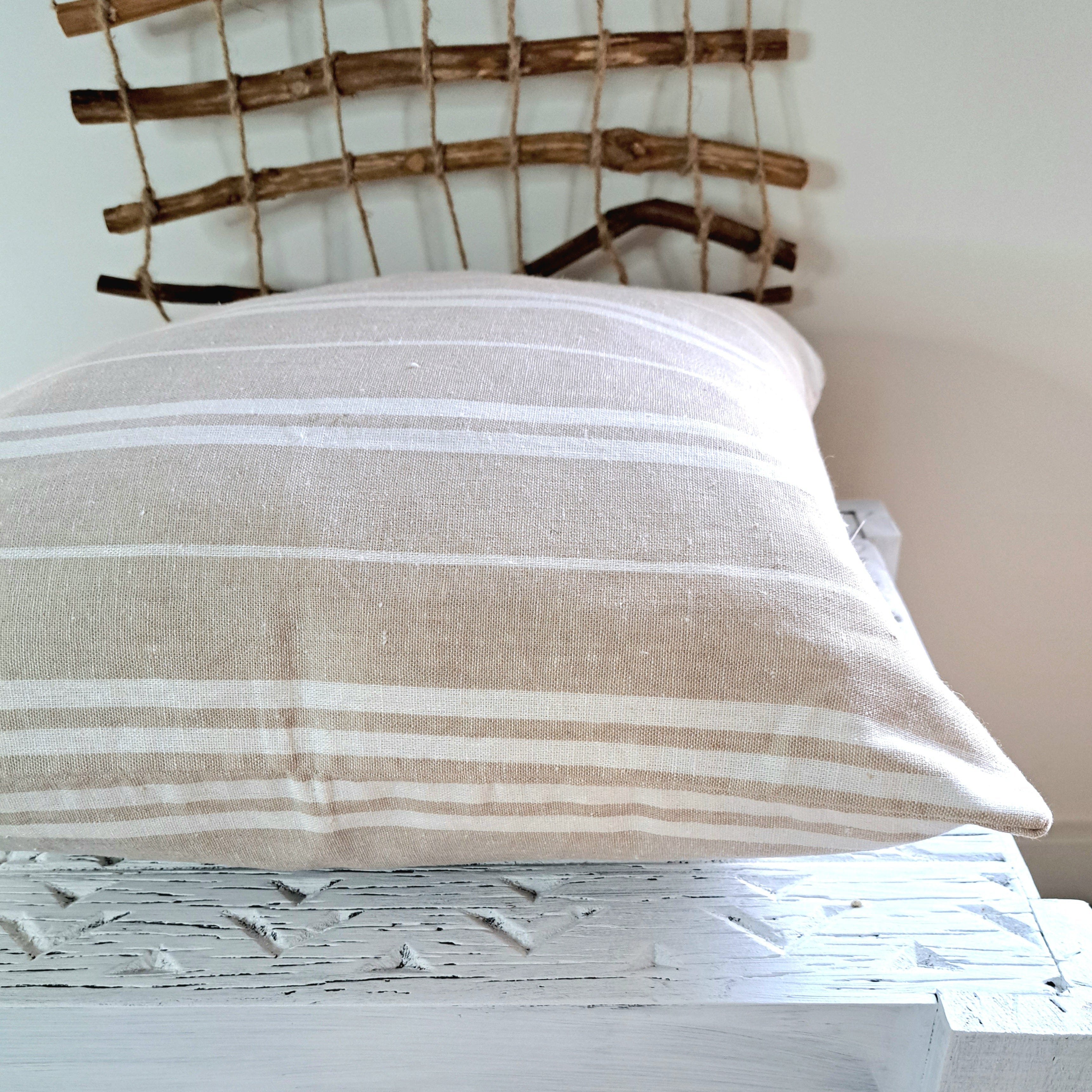 Oatmeal Stripe Linen Cushion Cover showcasing soft texture and warm oatmeal tone with white stripes on a decorative surface.
