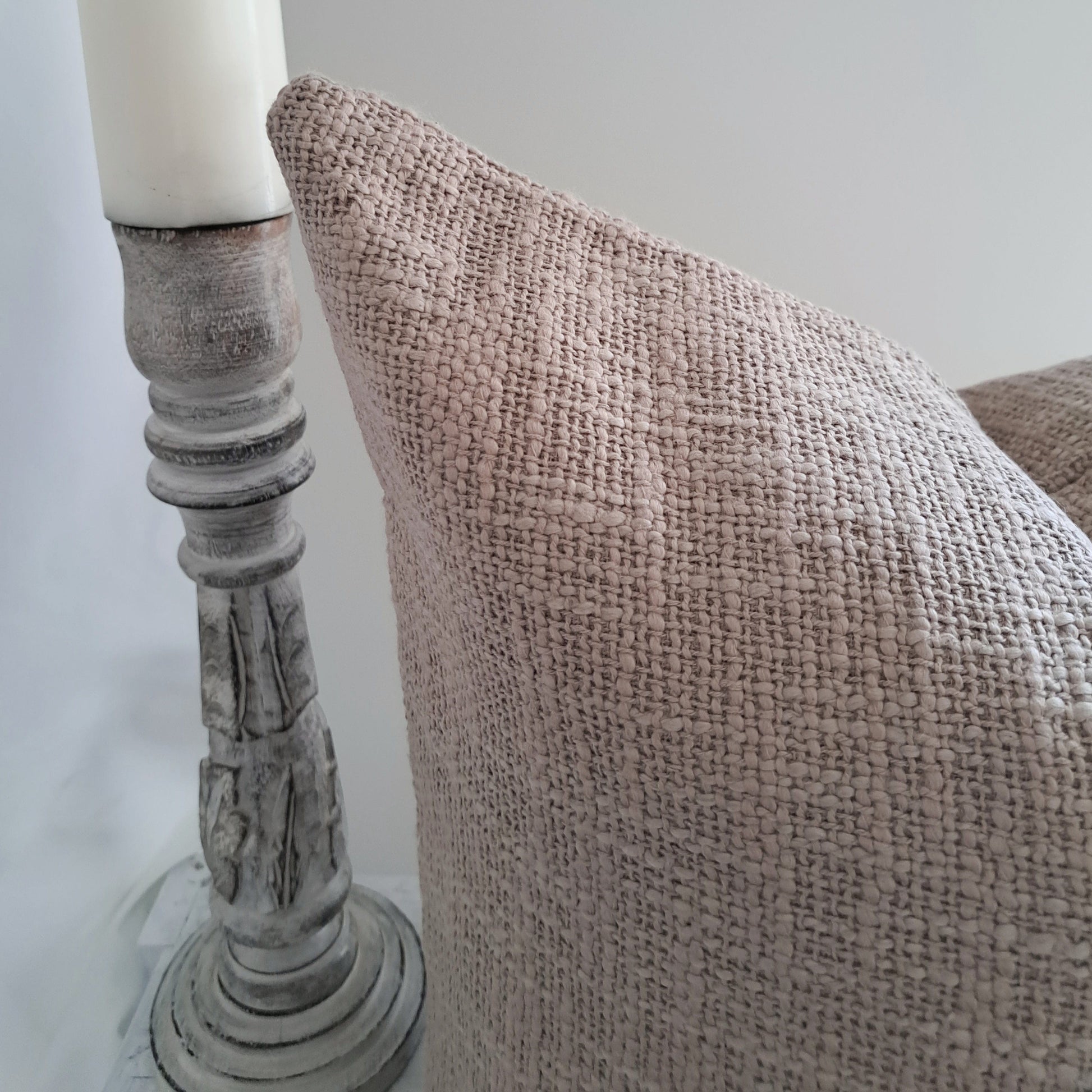 Close-up of Base Cushion Biscuit with textured cotton fabric beside a candle holder.
