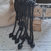 Castaway Bead Tassel Black decor with dark wooden beads and jute string in coastal home setting.
