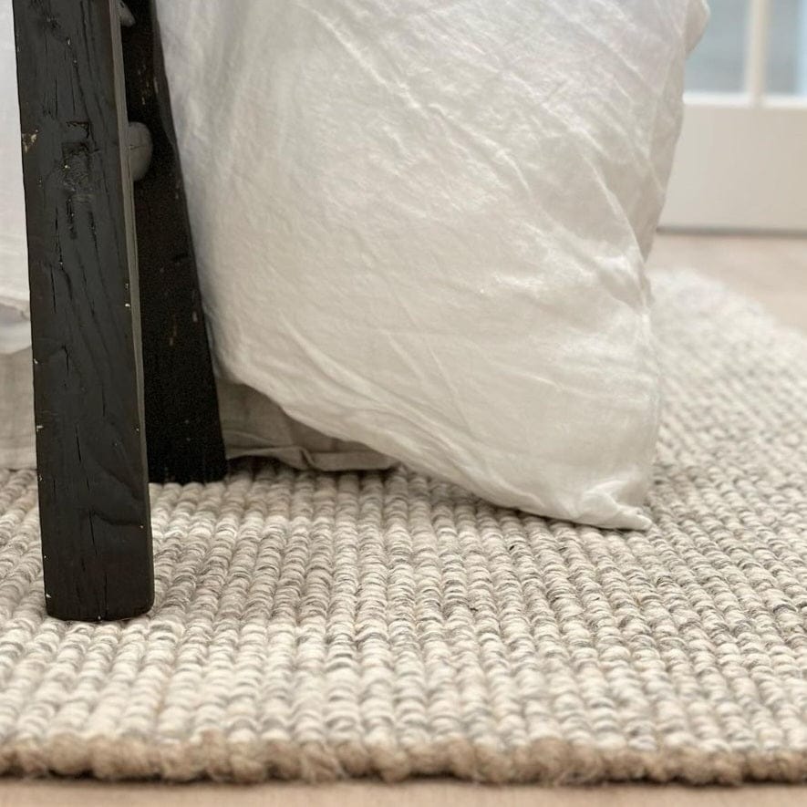 Jute Wool Rugs & Runners under a bed with a white pillow, showcasing natural texture and cozy home decor.