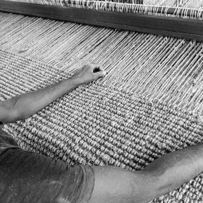 Artisan weaving Jute Wool Rugs & Runners, showcasing natural texture and craftsmanship.
