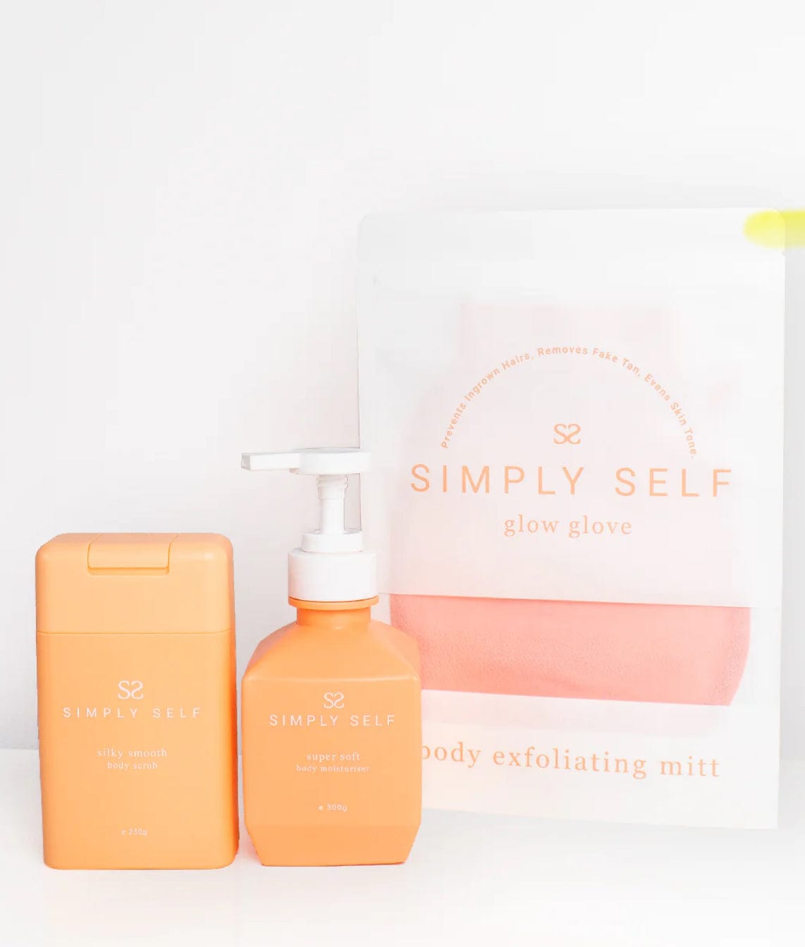 Simply Self Glow Essential Body Bundle with cleanser, exfoliating mitt, and nourishing lotion for radiant and soft skin care routine.