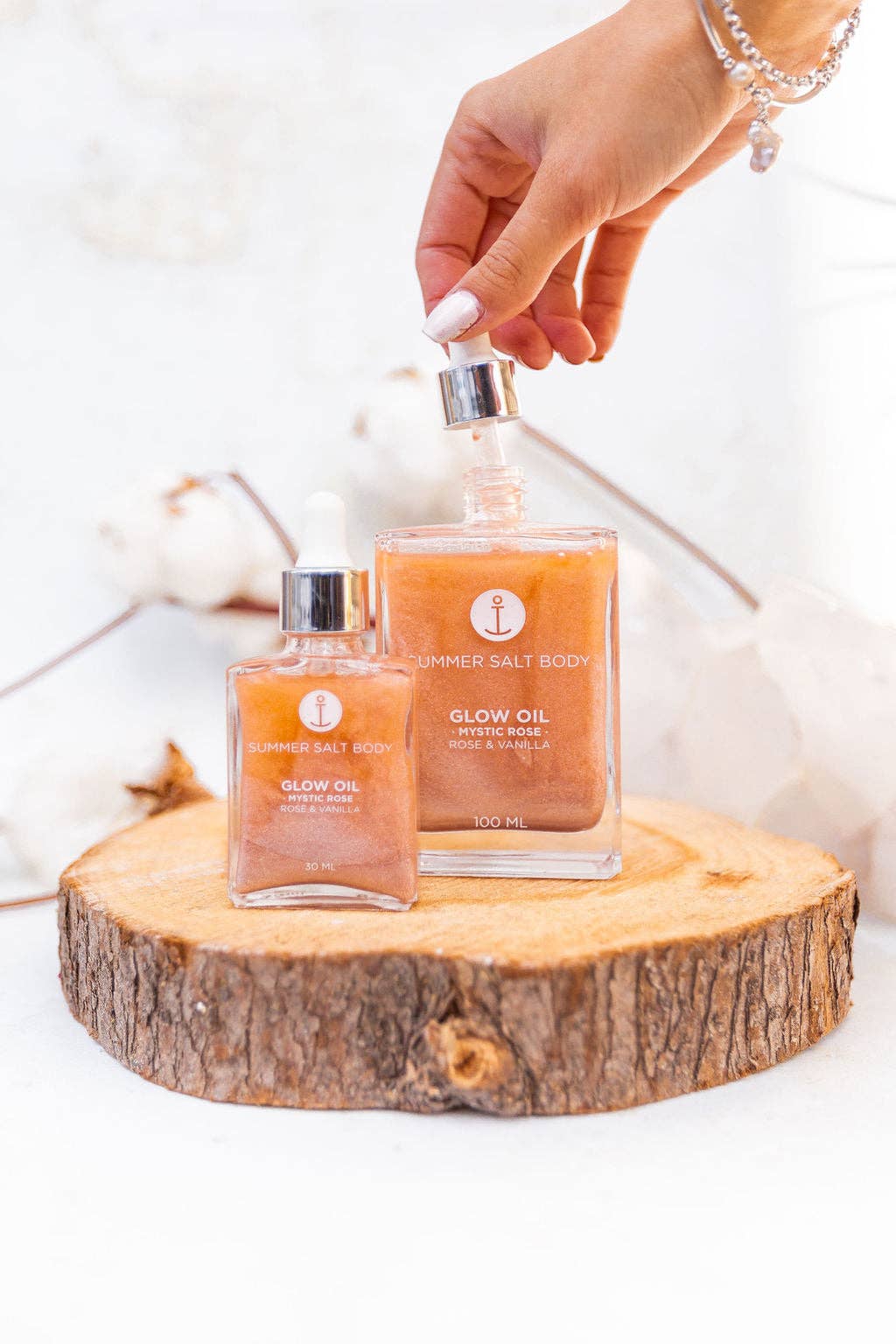 Summer Salt Body Mystic Rose Body Glow Oil bottles on a wooden surface.