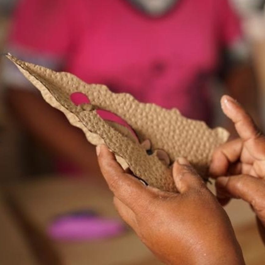 Person holding a piece of crafted paper for Paper Handmade Christmas Trees Natural decor.
